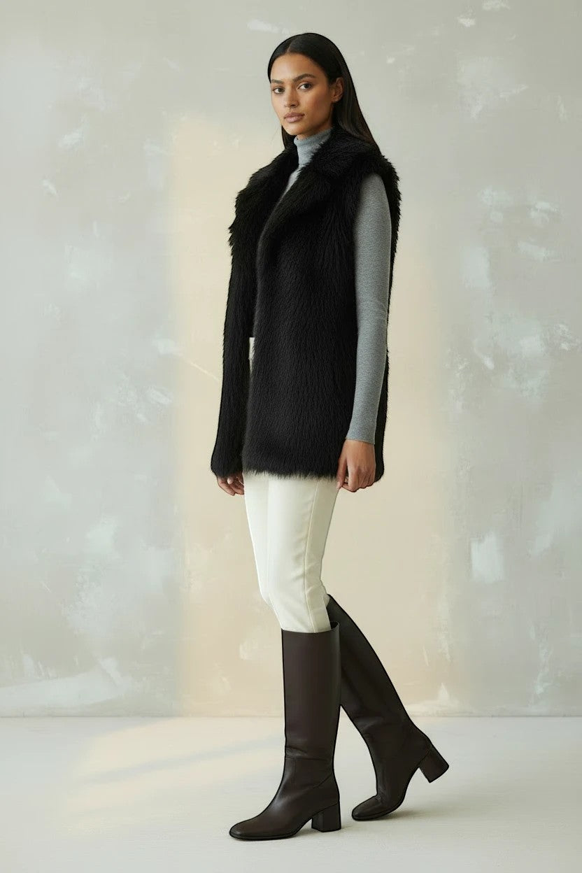 Refined Elegance black faux fur sleeveless vest worn by a model over a grey sweater and white trousers