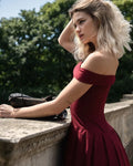 Refined Elegance burgundy corset mini dress in deep red with off-shoulder neckline and pleated skirt on a model.